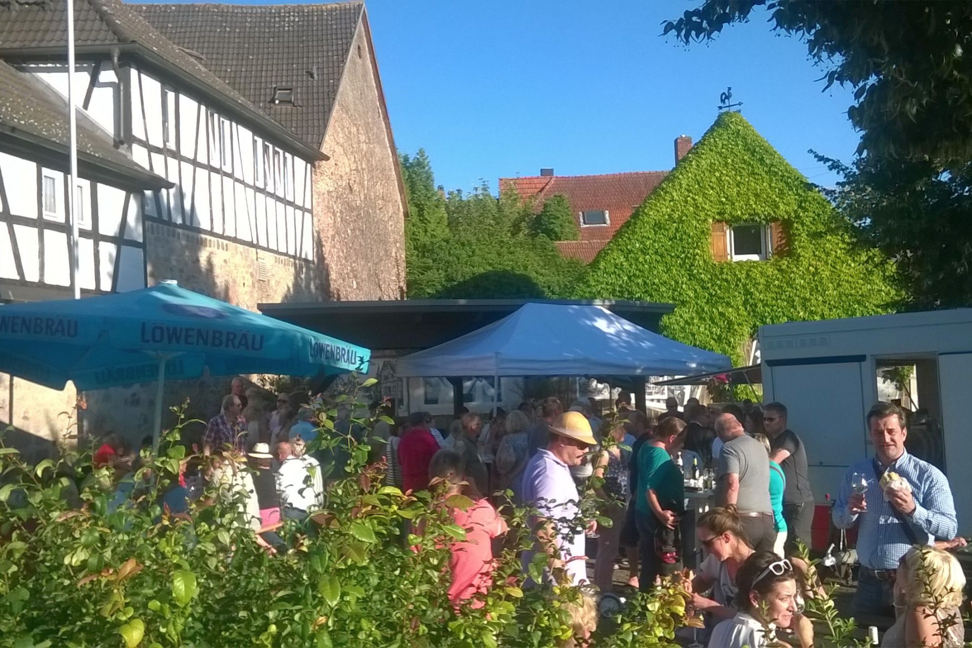 Dichtes Gedränge auf dem Dorfplatz während des Wochenmarkts.