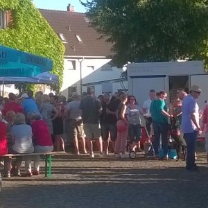 Dichtes Gedränge auf dem Dorfplatz während des Wochenmarkts.